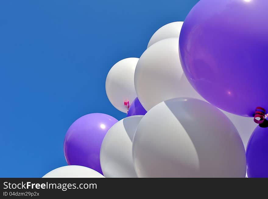 White and blue balloons in the city festival against clear sky