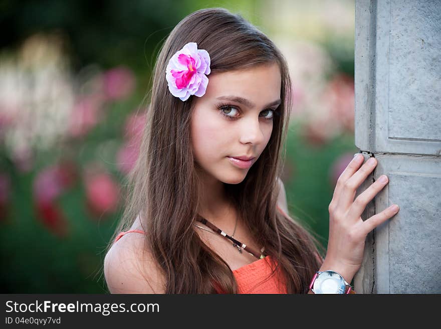 Portrait of beautiful fresh teenager girl with expressive look posing on a background of flowerbeds. Portrait of beautiful fresh teenager girl with expressive look posing on a background of flowerbeds