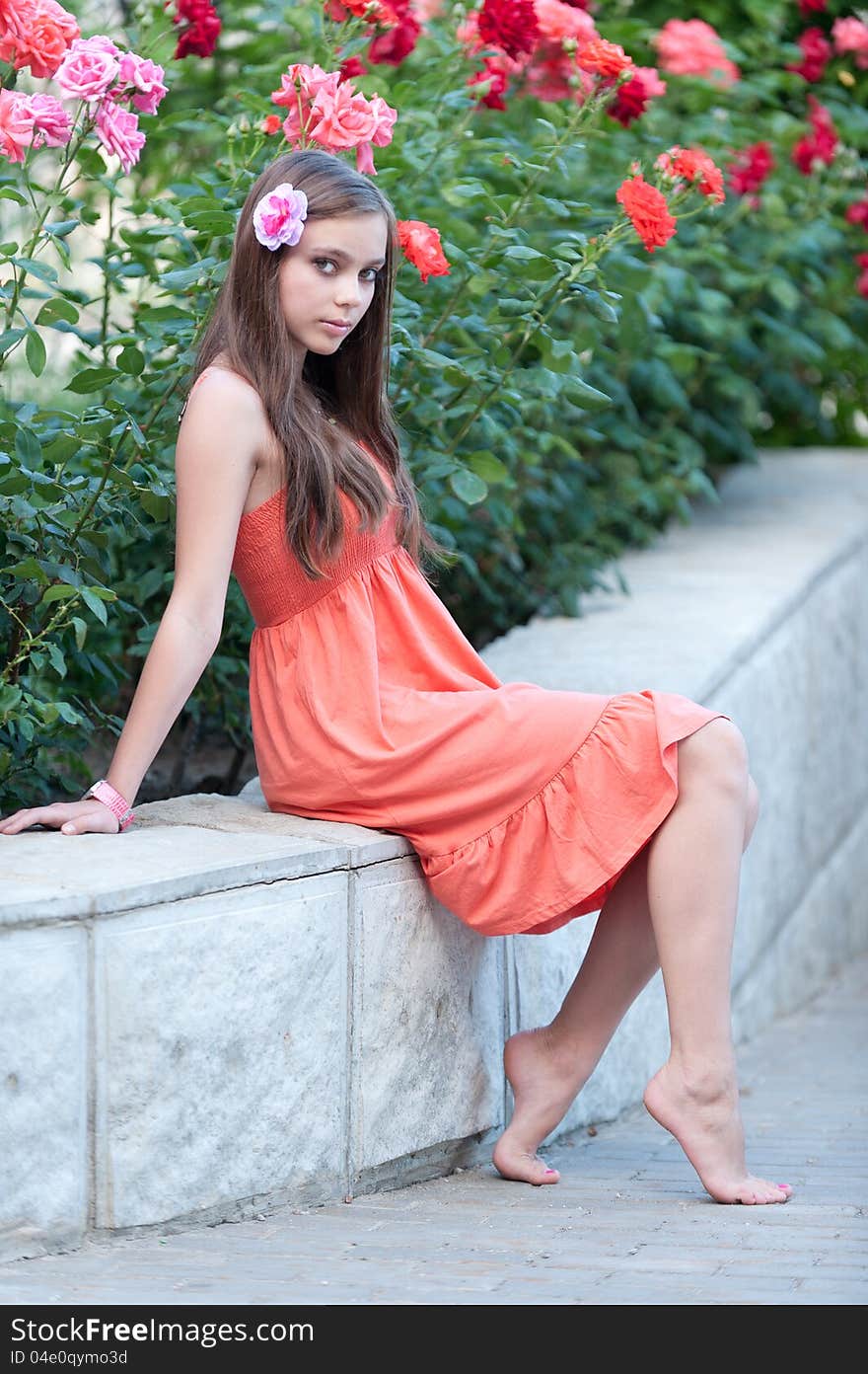 Portrait of beautiful fresh teenager girl with expressive look posing on a background of flowerbeds. Portrait of beautiful fresh teenager girl with expressive look posing on a background of flowerbeds