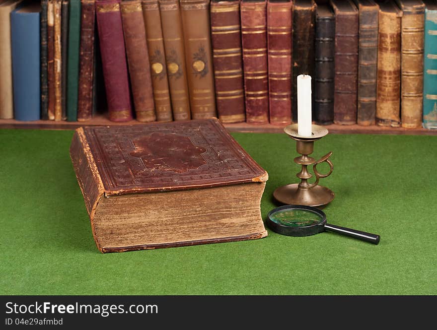 Antique book, candlestick and magnifying glass