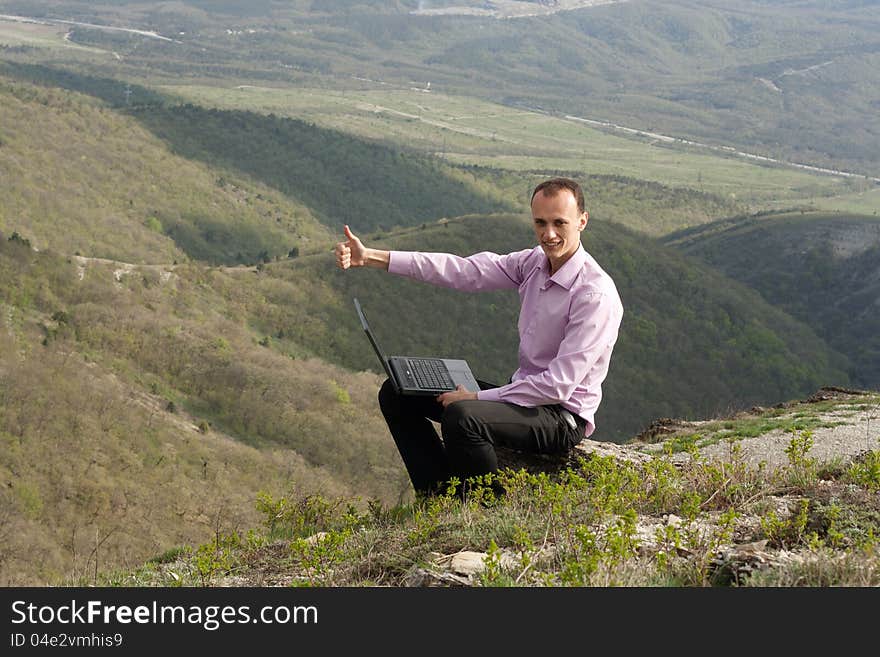 Man writes in notebook sitting on stone. Man writes in notebook sitting on stone