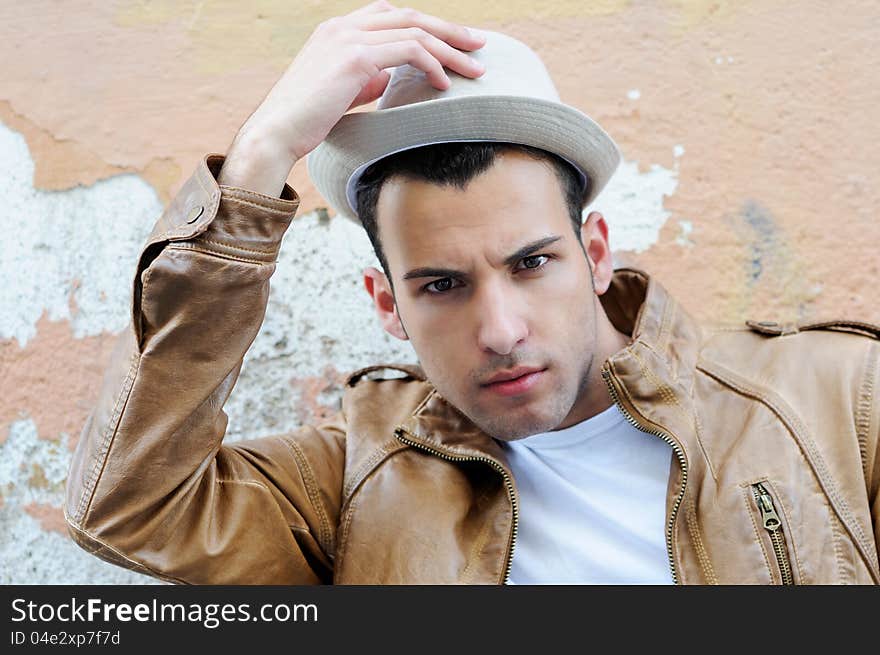 Portrait of a handsome young man with a hat in urban background. Portrait of a handsome young man with a hat in urban background