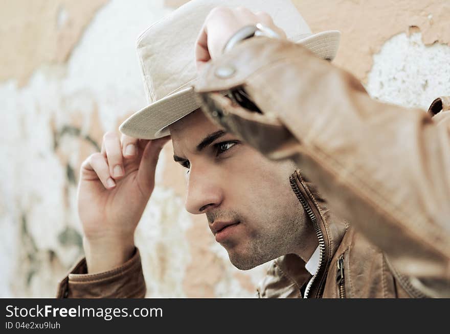 Portrait of a handsome young man with a hat in urban background. Portrait of a handsome young man with a hat in urban background