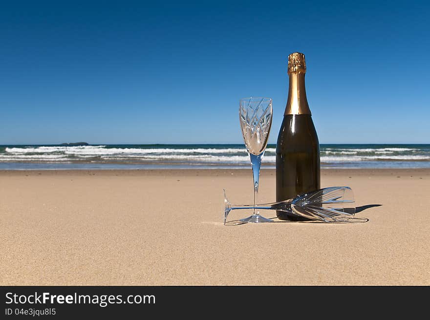 Bottle of champagne with two crystals glasses on a secluded beach. Bottle of champagne with two crystals glasses on a secluded beach.