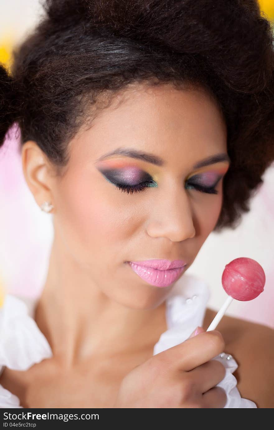 Beautiful afro-american woman holding lollipop on colorful background. Beautiful afro-american woman holding lollipop on colorful background