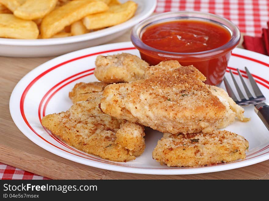 Breaded fish dinner with french fries in background