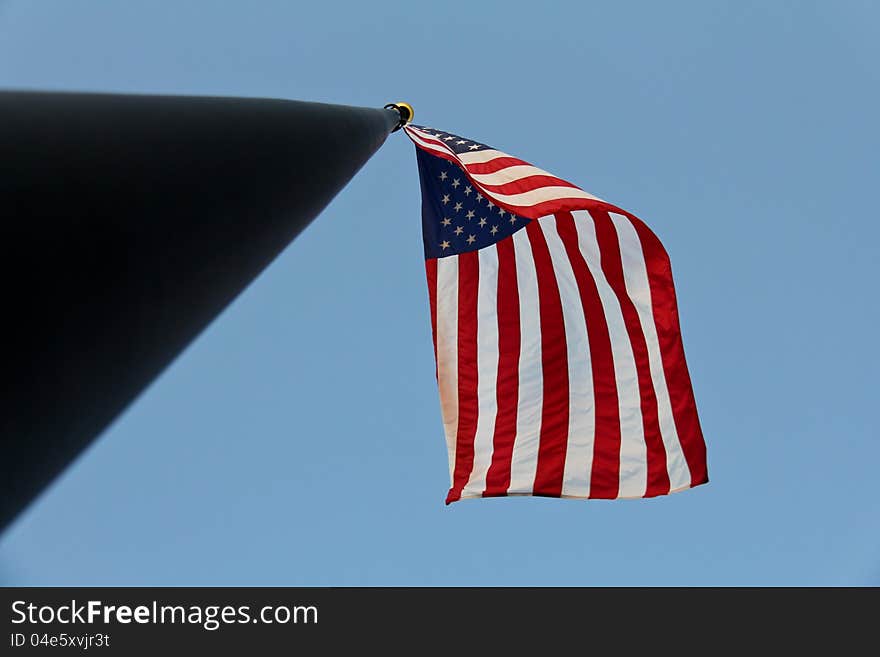 Image of a flag flying on a staff shot from directly underneath. Image of a flag flying on a staff shot from directly underneath