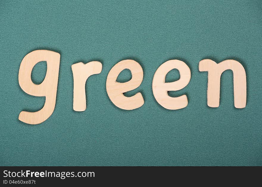 The word Green in wooden letters on a green textured background