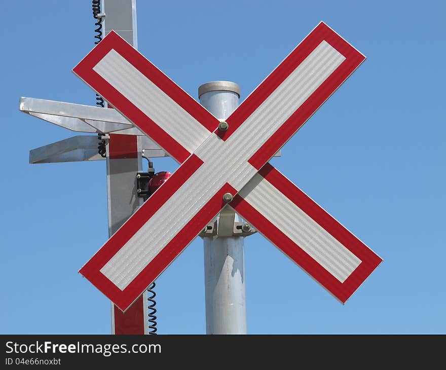 Close-up of an X railroad crossing warning sign against a blue sky. Close-up of an X railroad crossing warning sign against a blue sky.