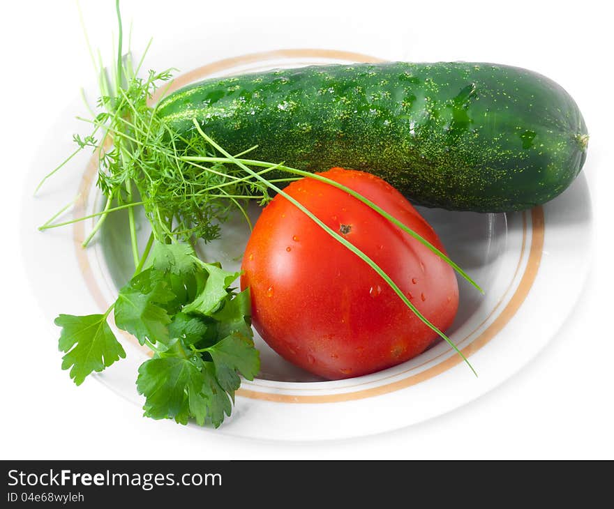 A shot from above of tomato, cucumber, celery, garlic and dill lying on a glass plate;. A shot from above of tomato, cucumber, celery, garlic and dill lying on a glass plate;