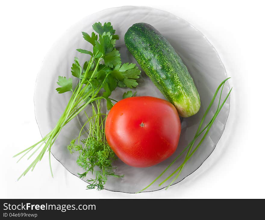 A shot from above of tomato, cucumber, celery, garlic and dill lying on a glass plate;. A shot from above of tomato, cucumber, celery, garlic and dill lying on a glass plate;