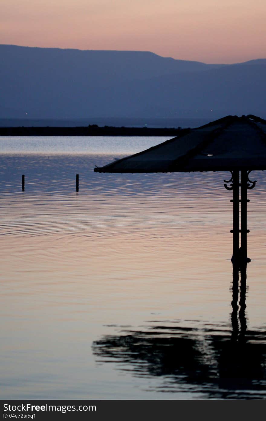 Beach umbrella at sunrise dead sea israel