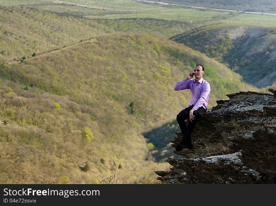 Man in mountain talks the telephone. Man in mountain talks the telephone