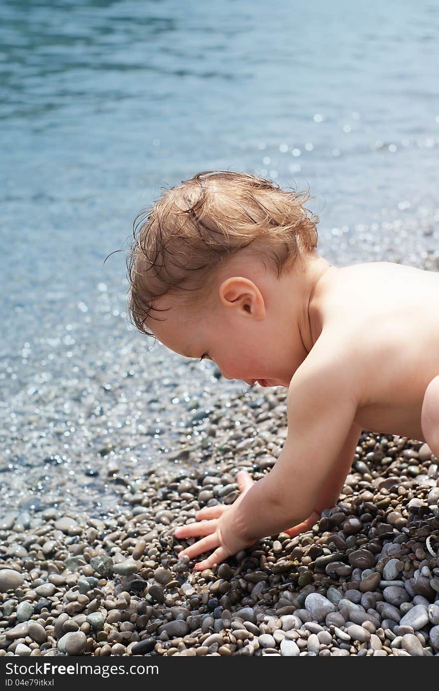 The child crawls into the sea to swim. The child crawls into the sea to swim