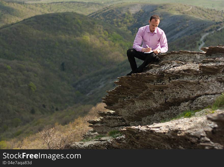 Man with notepad on stone