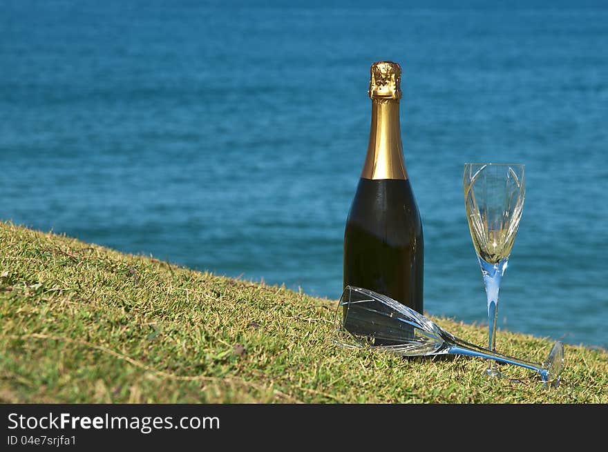 Champagne and glasses on the top of a headland overlooking the ocean. Champagne and glasses on the top of a headland overlooking the ocean.