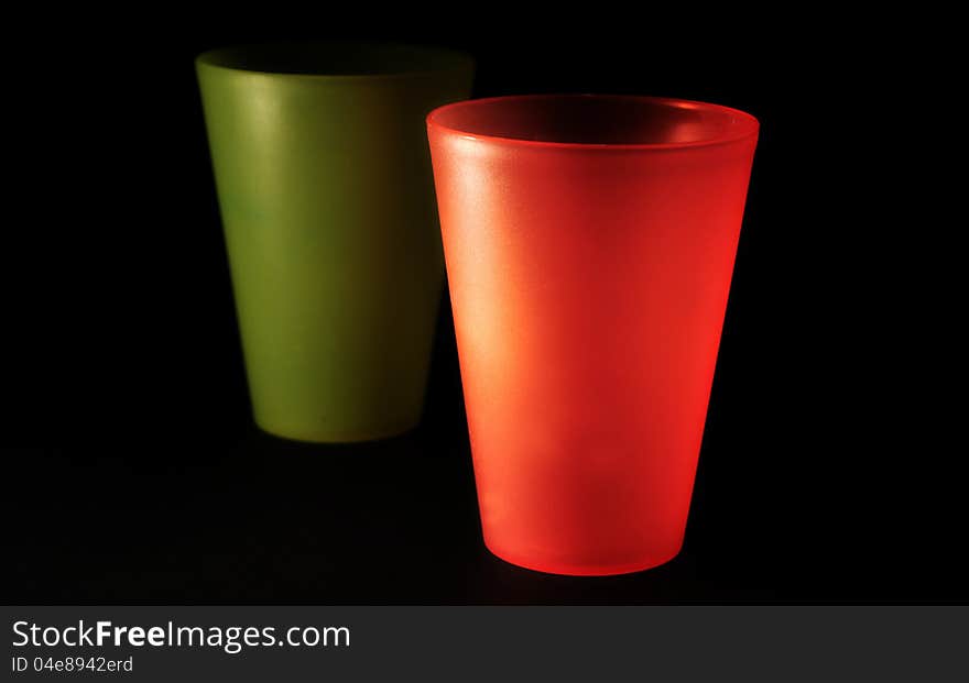 Red and green plastic glasses over black. Red and green plastic glasses over black