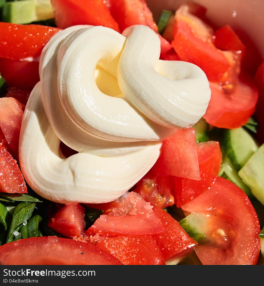 Salad from tomatoes, cucumbers and an onions with sour cream