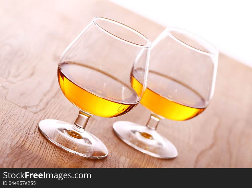 Glass Of Cognac Over Wooden Surface