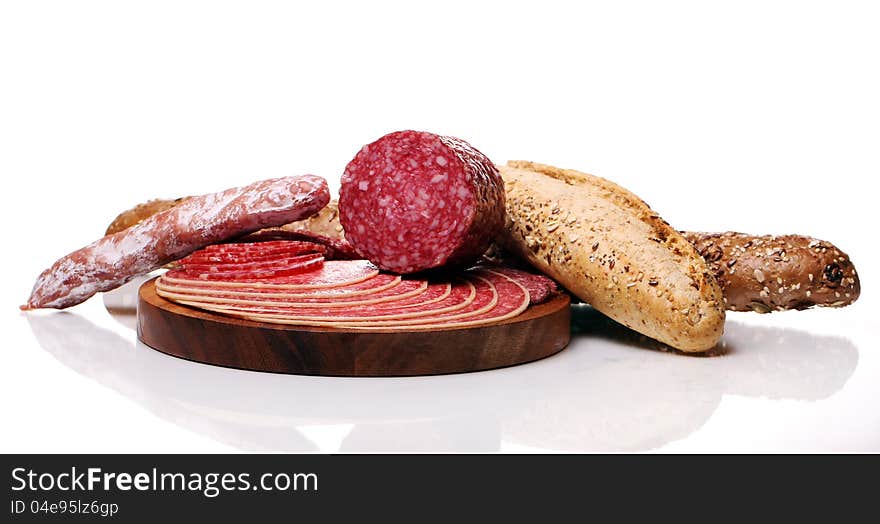 Salami and bread over white background