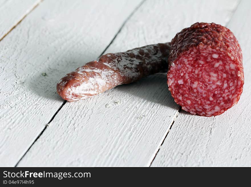 Fresh and delicious salami over wooden surface