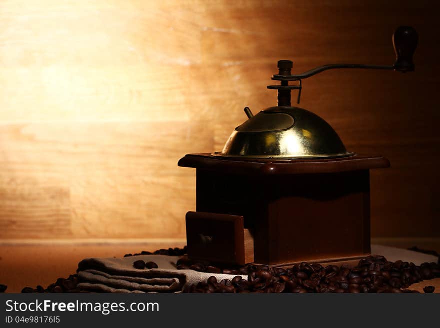 Old coffee grinder on wooden background