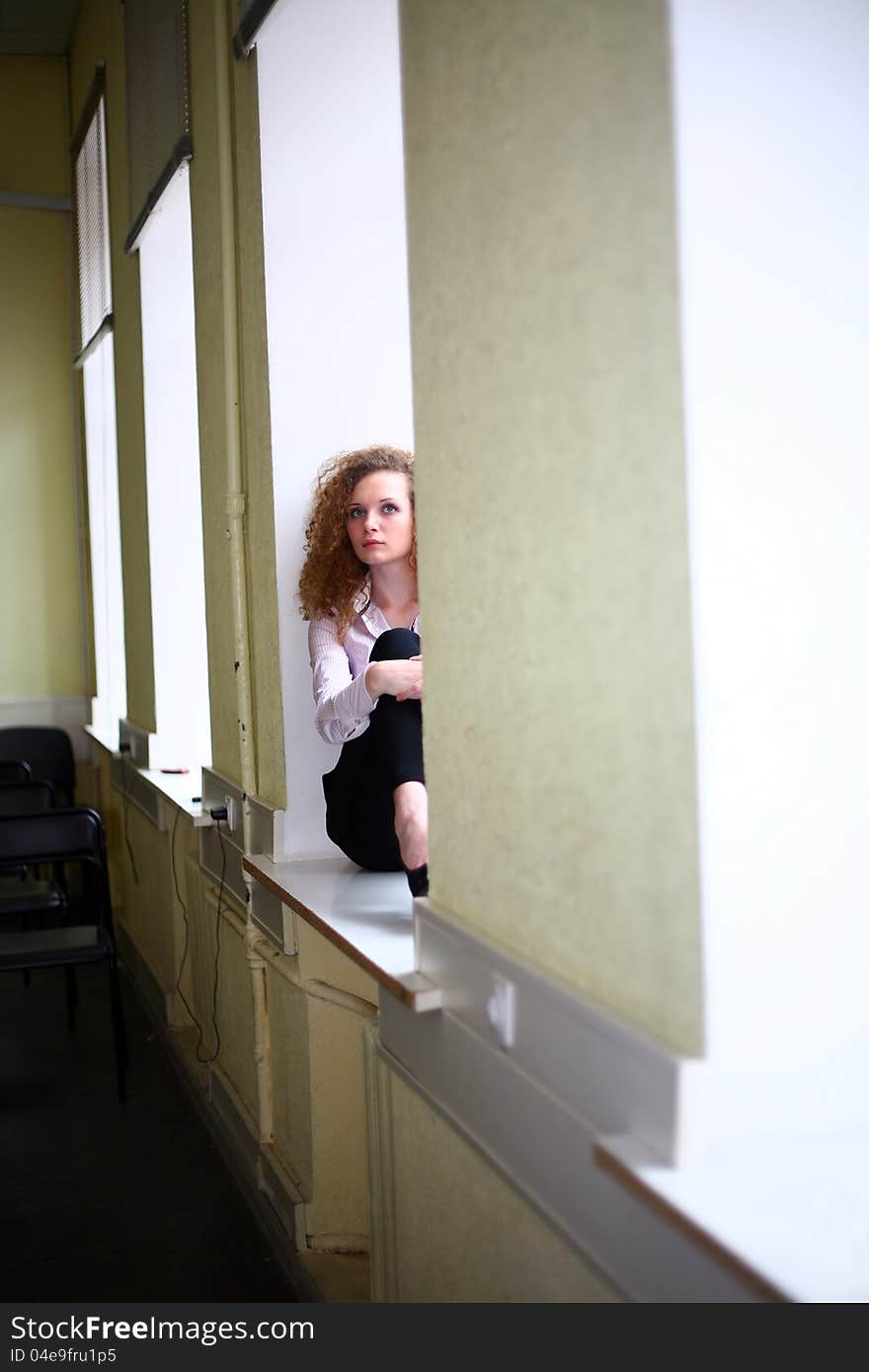 Curly-haired student on the window sill. Curly-haired student on the window sill