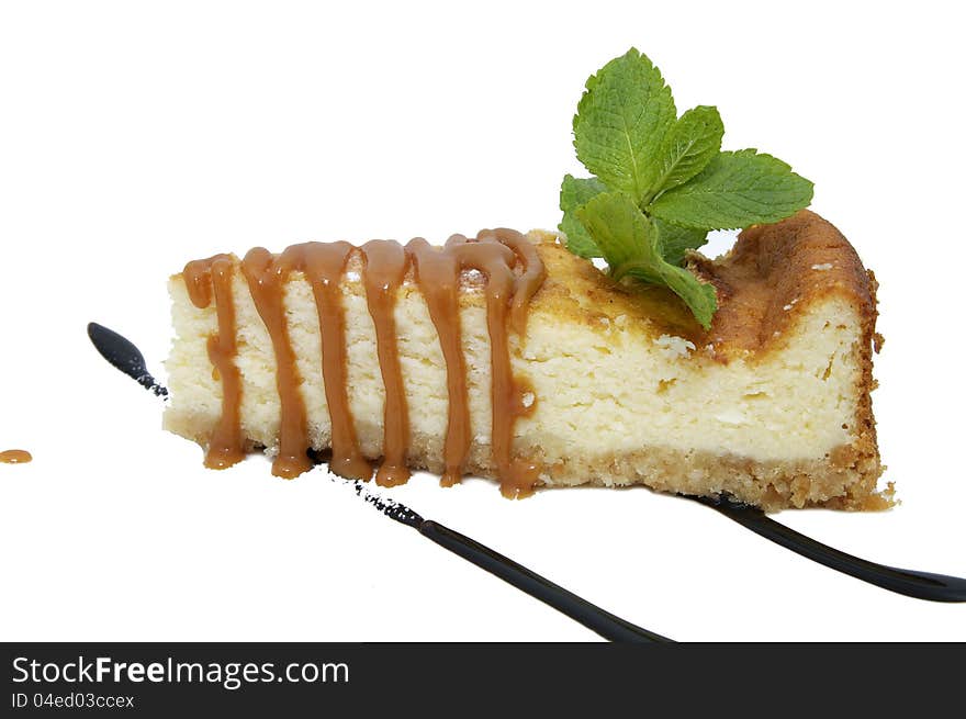 A piece of cheese cake decorated with mint leaves. A piece of cheese cake decorated with mint leaves