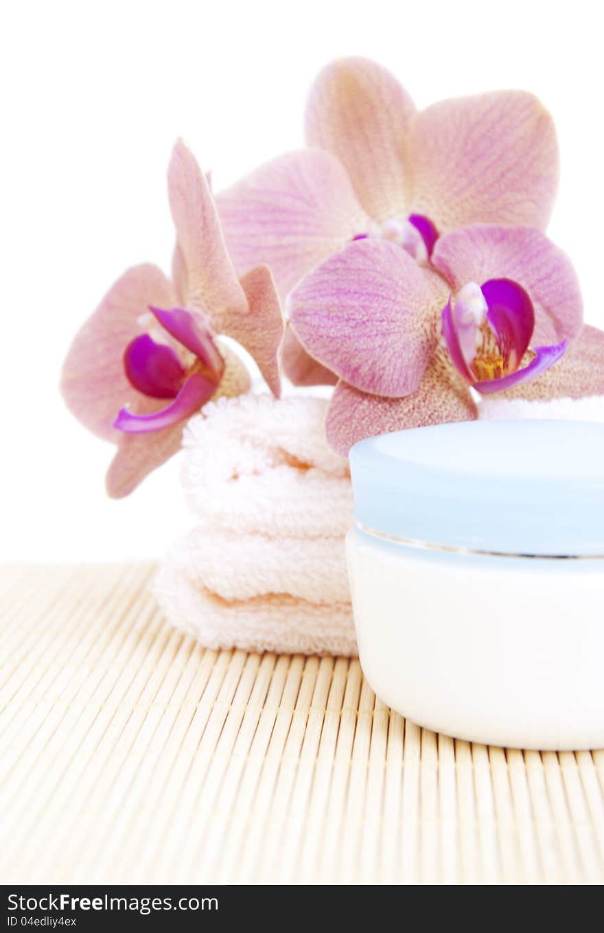 Cosmetic moisturizing cream with pink orchids and towel. Cosmetic moisturizing cream with pink orchids and towel