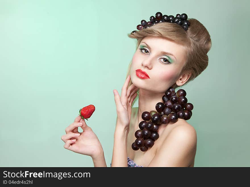 Woman with strawberry and bunch of grapes