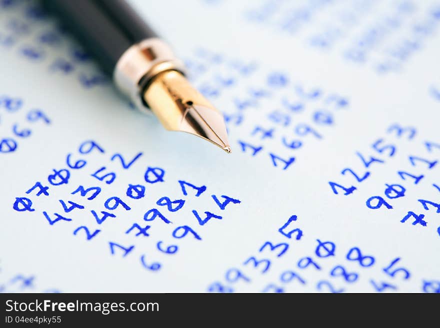 Closeup of fountain pen on paper with columns of written numbers. Closeup of fountain pen on paper with columns of written numbers