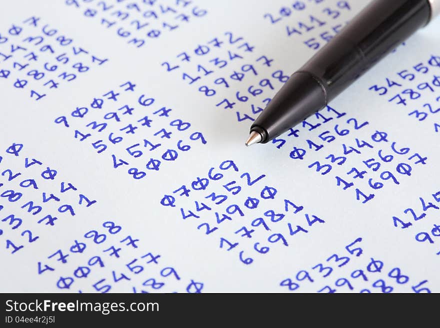 Closeup of bollpoint pen on paper with columns of written numbers. Closeup of bollpoint pen on paper with columns of written numbers