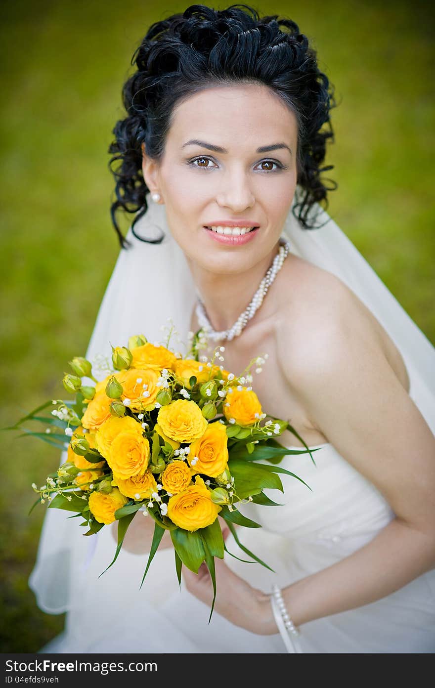 Portrait of beautiful young bride in garden .Play with bouquet