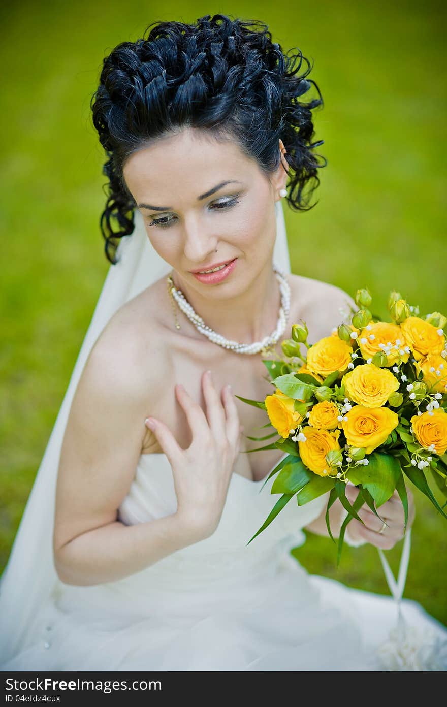 Portrait of beautiful young bride in garden .Play with bouquet