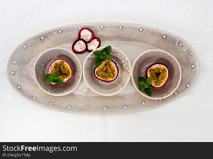 Bowls of Granadilla sliced with mint and isolated on white