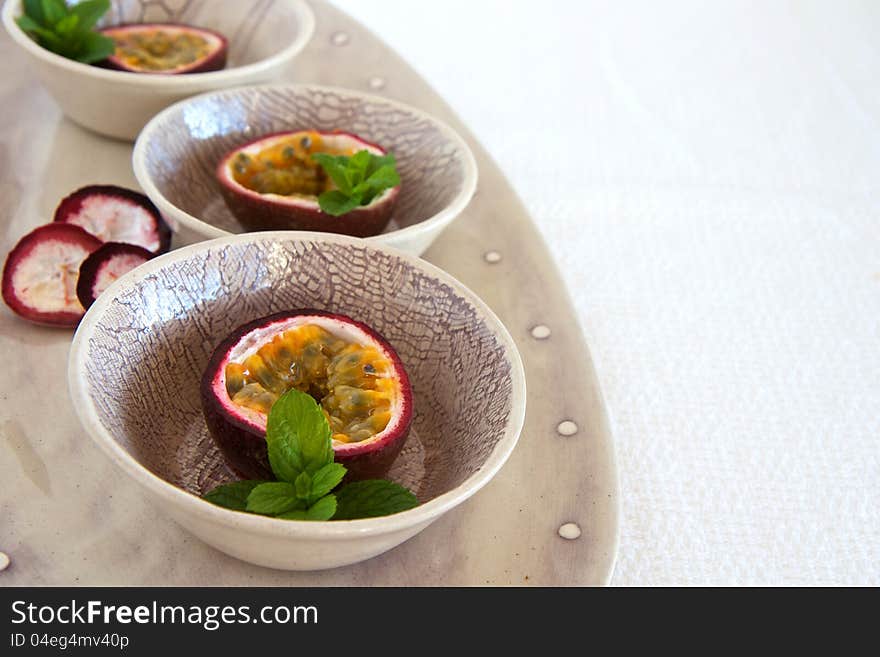 Granedilla fruits with mint on a plate. Granedilla fruits with mint on a plate