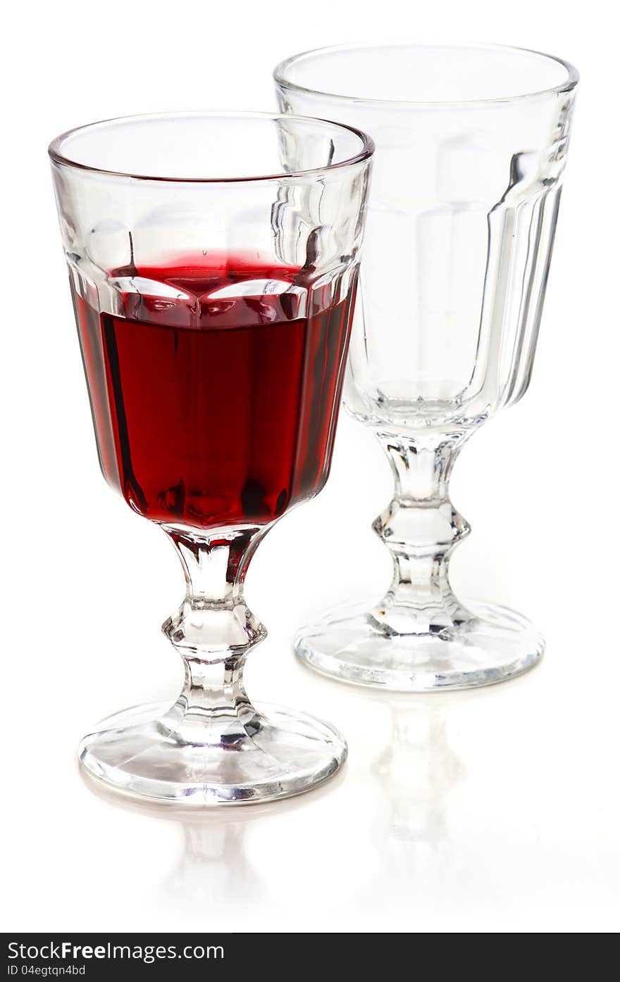 Glass of red wine and empty glass with reflection on a white background. Glass of red wine and empty glass with reflection on a white background.