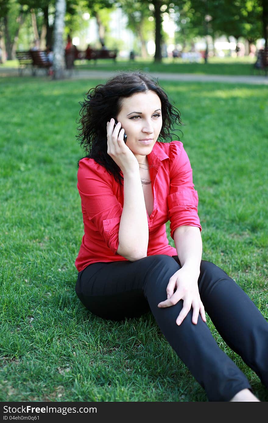 Pretty girl on the phone in the park summer