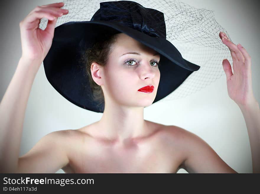 Portrait of a cute girl in a hat with red lips