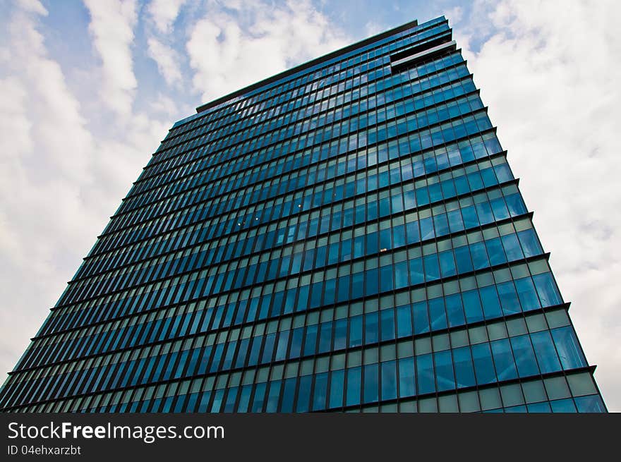 Exterior view of a high rise office building in Romania with a cloudscape background. Exterior view of a high rise office building in Romania with a cloudscape background.