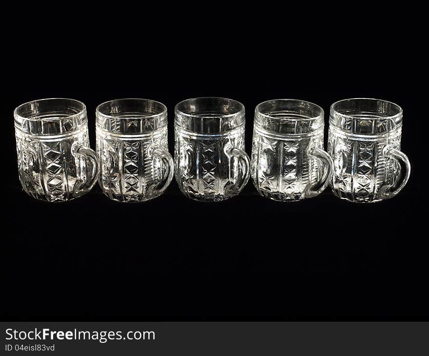 Five empty beer glasses on a black background