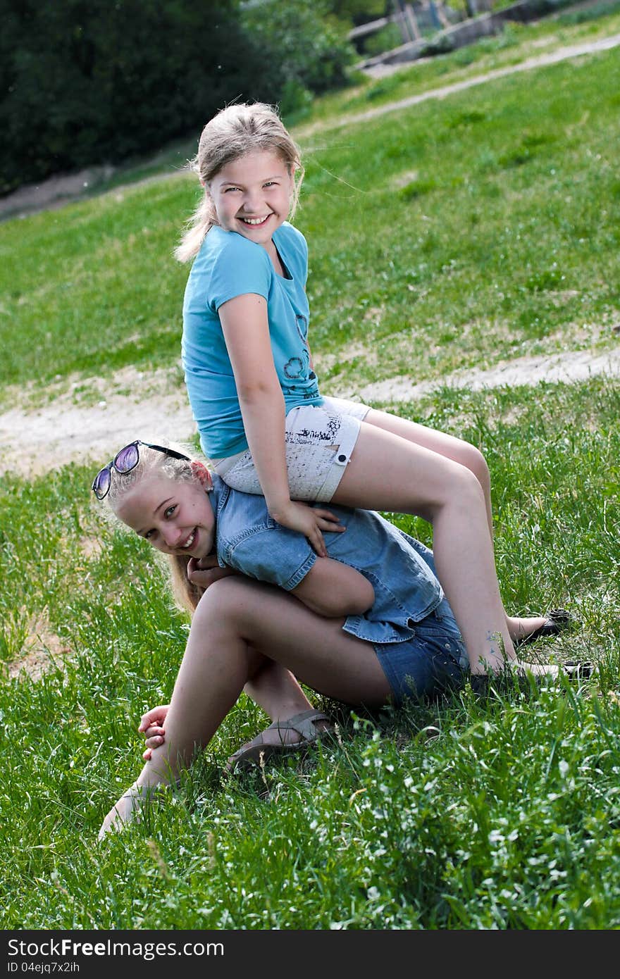 Two nice girls play and laught in the meadow