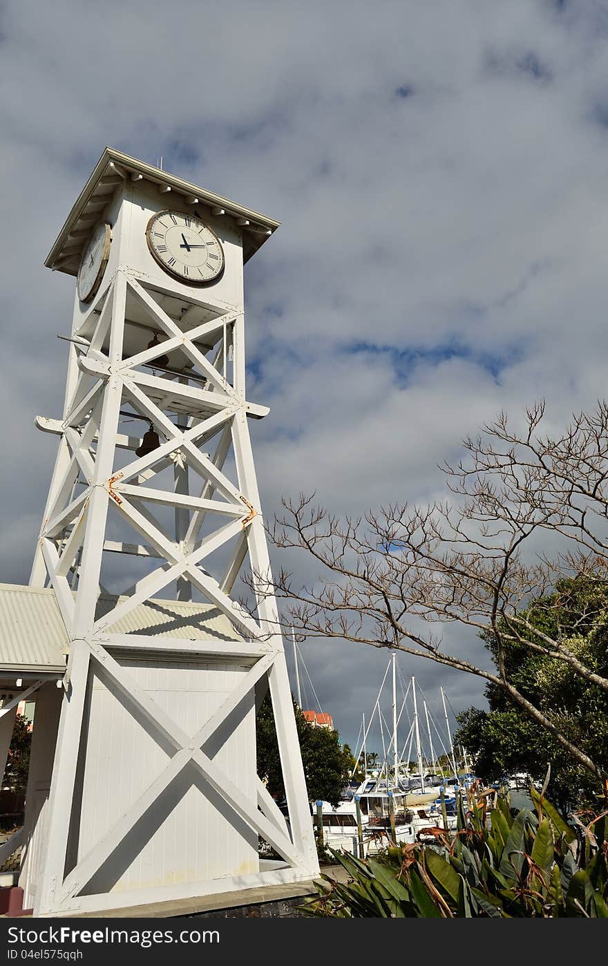 Clock tower with a marina in the background.