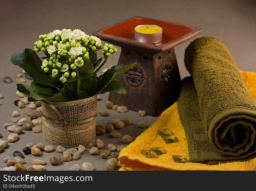 Tranquil spa scene with towels, candle, flower and decoration