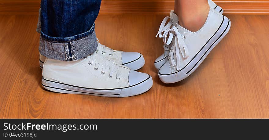 Man and woman in the same sneakers are opposite each other. Man and woman in the same sneakers are opposite each other