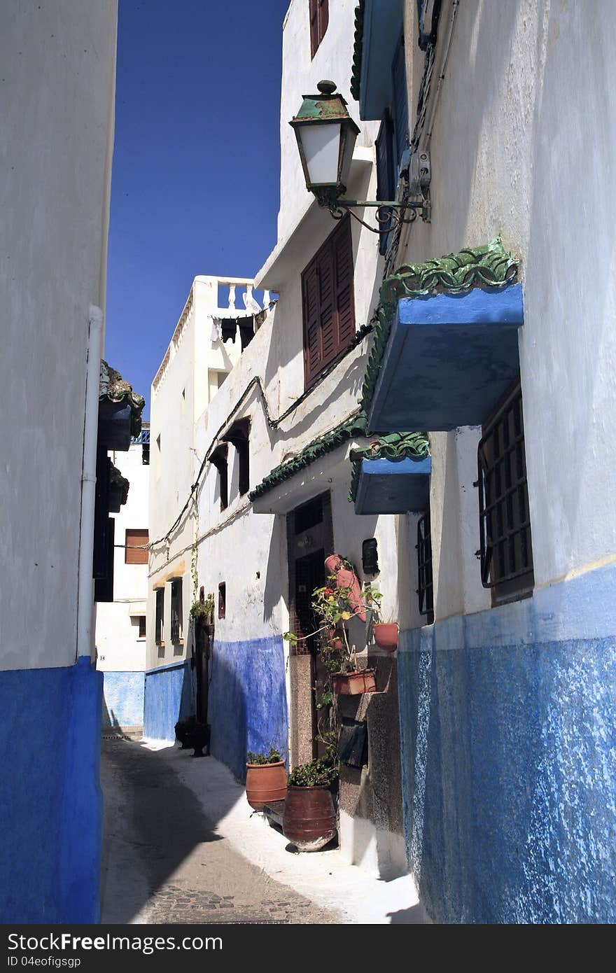 Narrow streets with brightly painted blue and white walls contrast against the blue sky while keeping cool under the warm middle- eastern sun. Narrow streets with brightly painted blue and white walls contrast against the blue sky while keeping cool under the warm middle- eastern sun.