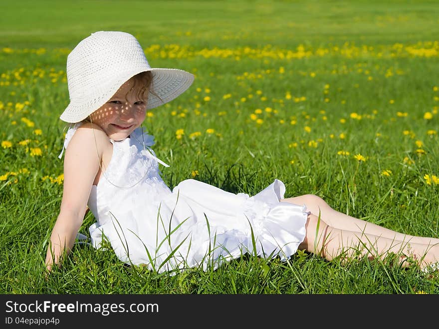 Happy little girl lying on grass