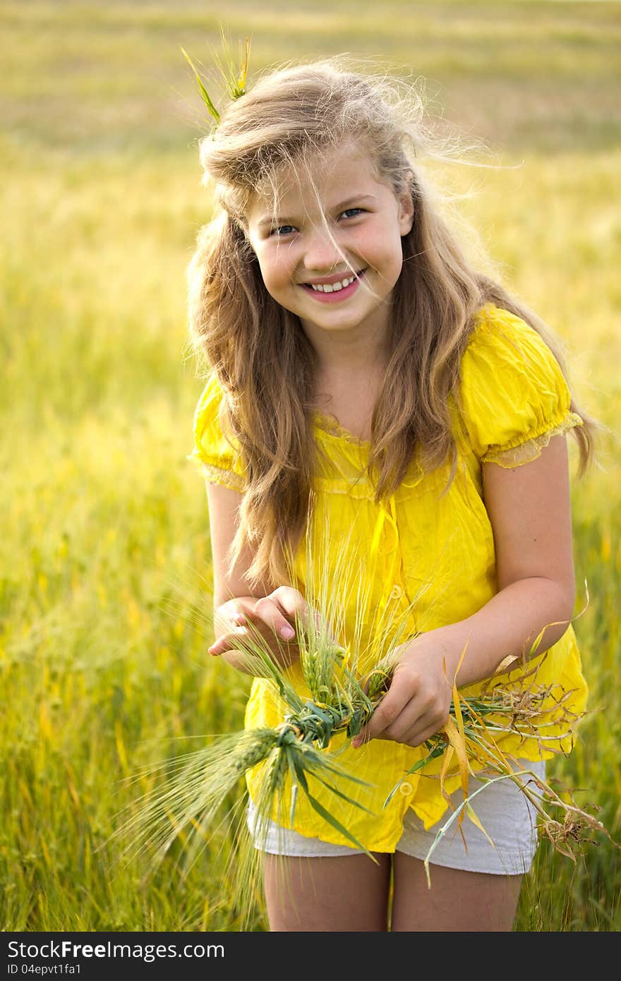 Cute girl on the weat meadow in summer day weaves a wreath. Cute girl on the weat meadow in summer day weaves a wreath