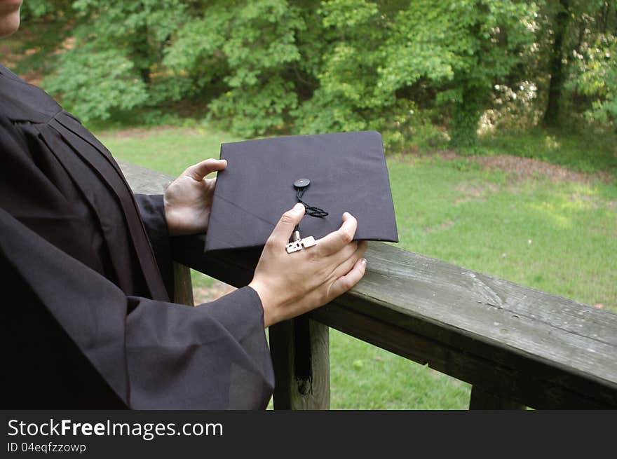 A young graduate holding her cap and staring off into the distance. Area left at right for writing, etc. A young graduate holding her cap and staring off into the distance. Area left at right for writing, etc.