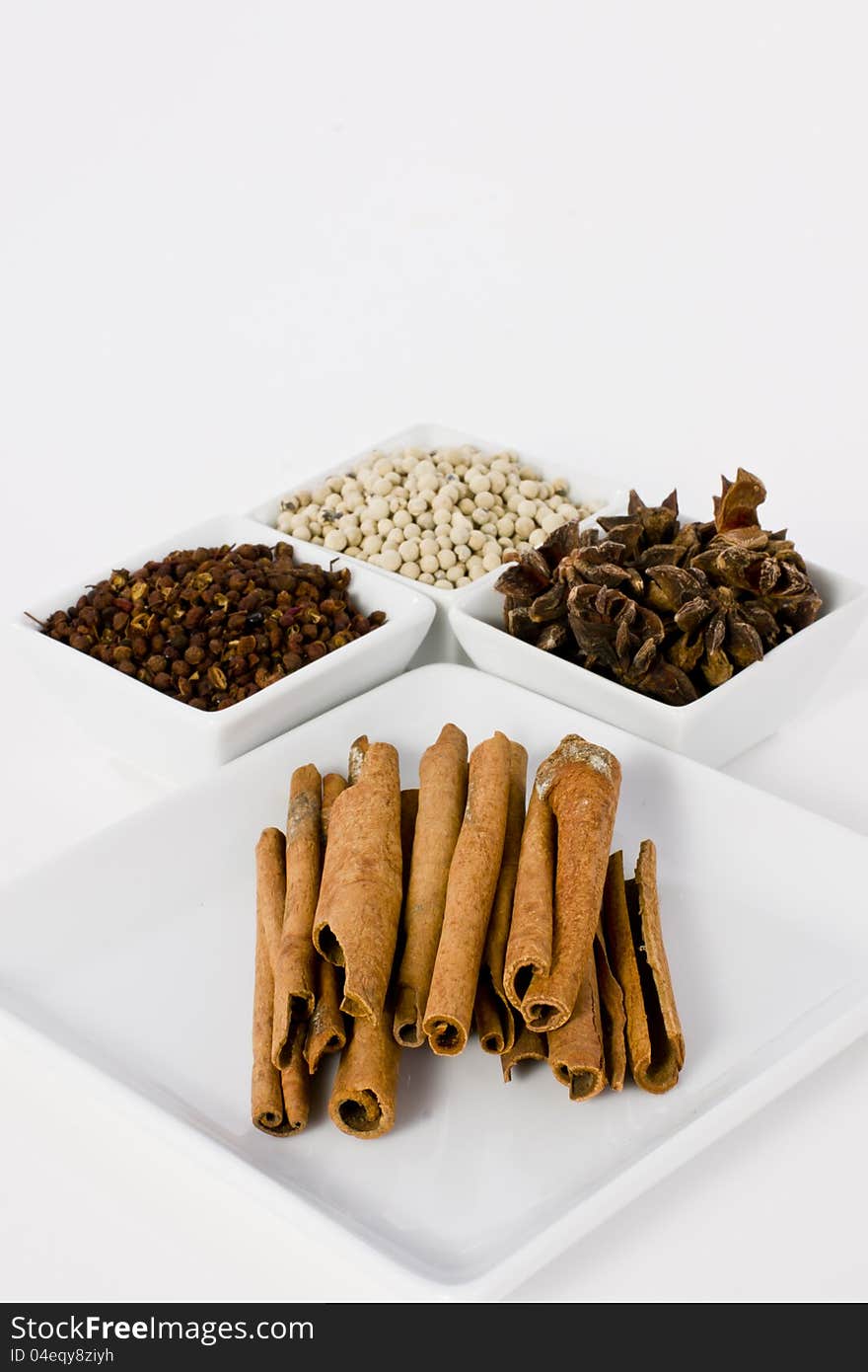 Star Anise, Cinnamon, White Pepper and Coriander Seed in Ceramic Bowl on White Background. Star Anise, Cinnamon, White Pepper and Coriander Seed in Ceramic Bowl on White Background